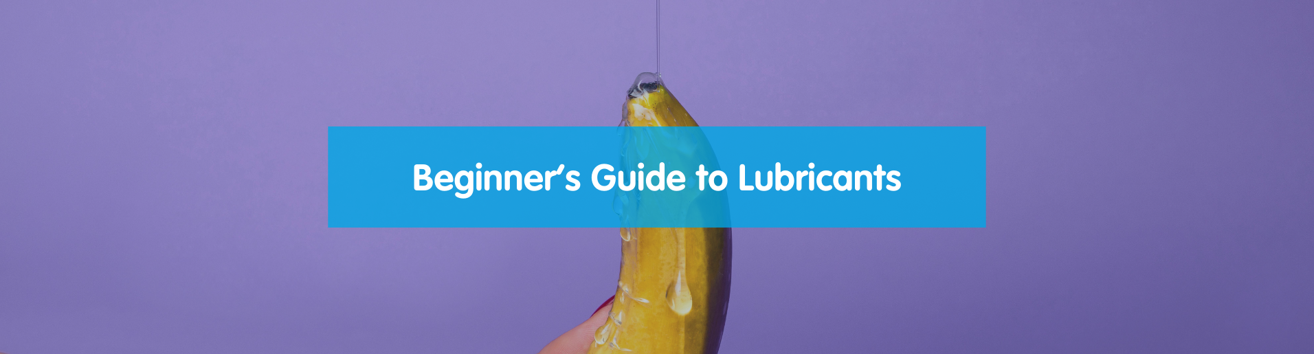 Beginner's guide to lubricants. A banana with a condom on being held while lube drips on it.