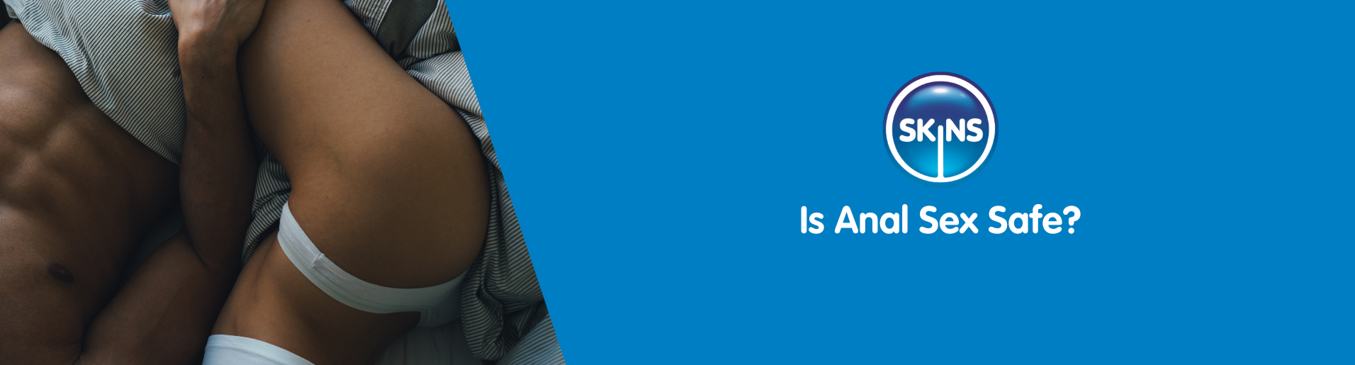 A young, half-naked couple laid in bed together