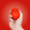 A woman's hand holding the Skins Lix Rose Buddy on a red background