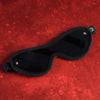 Black sleep mask on a red textured background