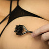 Person using a gunmetal wartenberg wheel on their skin