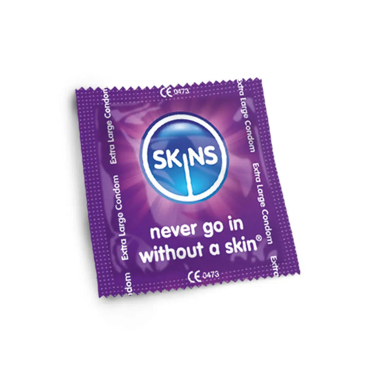 Purple condom package with 'SKINS' branding on a white background