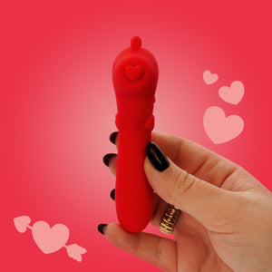 Red heart-shaped toy held by a hand on a pink background with hearts.