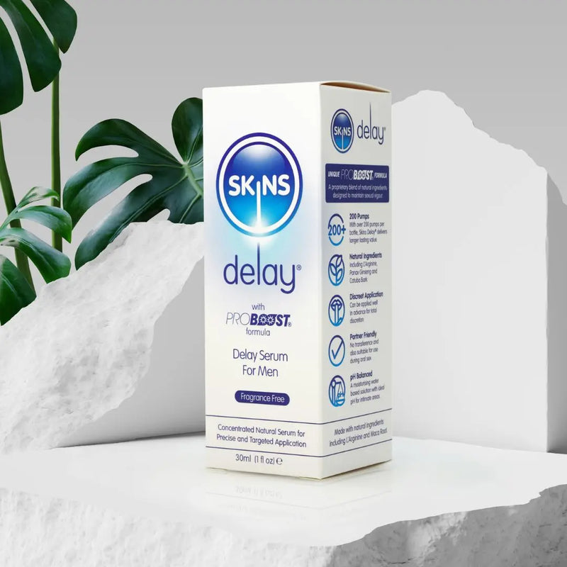 A Skins Delay sat on a white concrete block with a green plant in the background