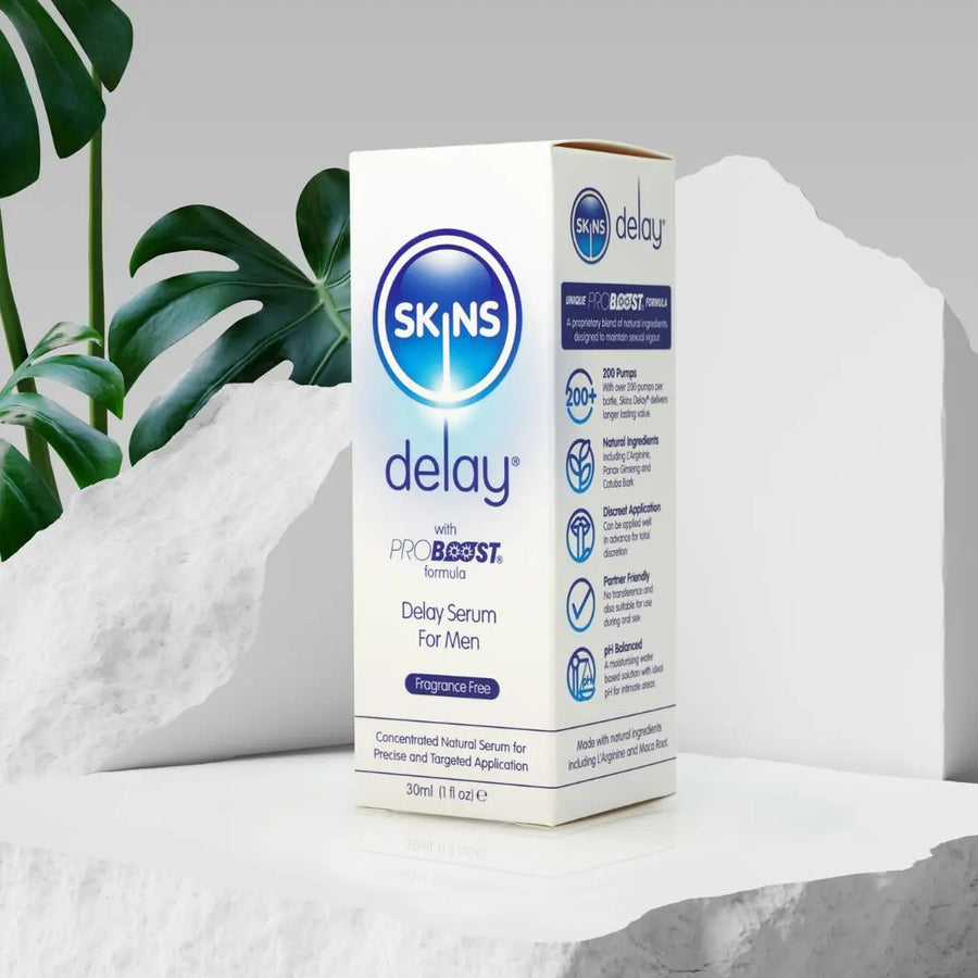 A Skins Delay sat on a white concrete block with a green plant in the background