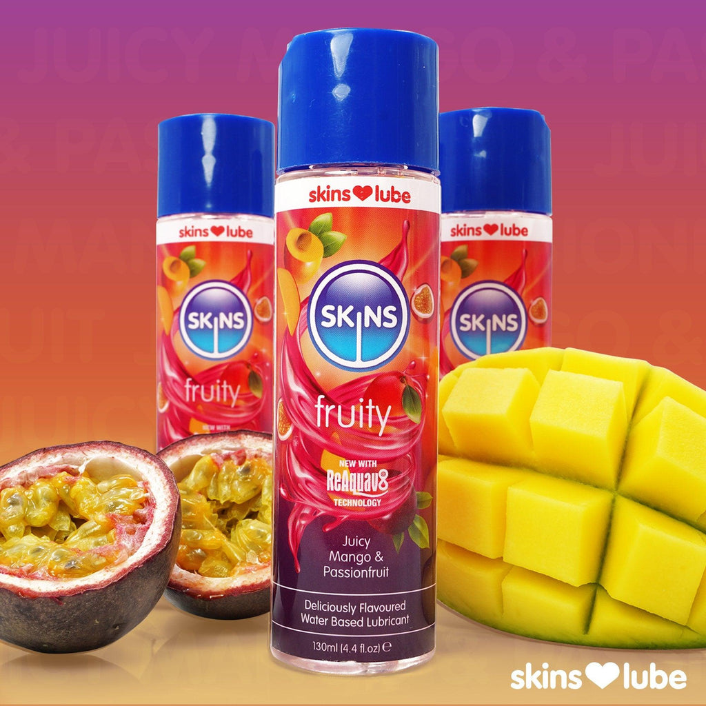 A purple to orange gradient background, 3 Mango & Passionfruit 130ml lube bottles in the middle, 1 bottle at the forefront, 2 behind. On the left 2 passionfruit halves, and on the right an open mango